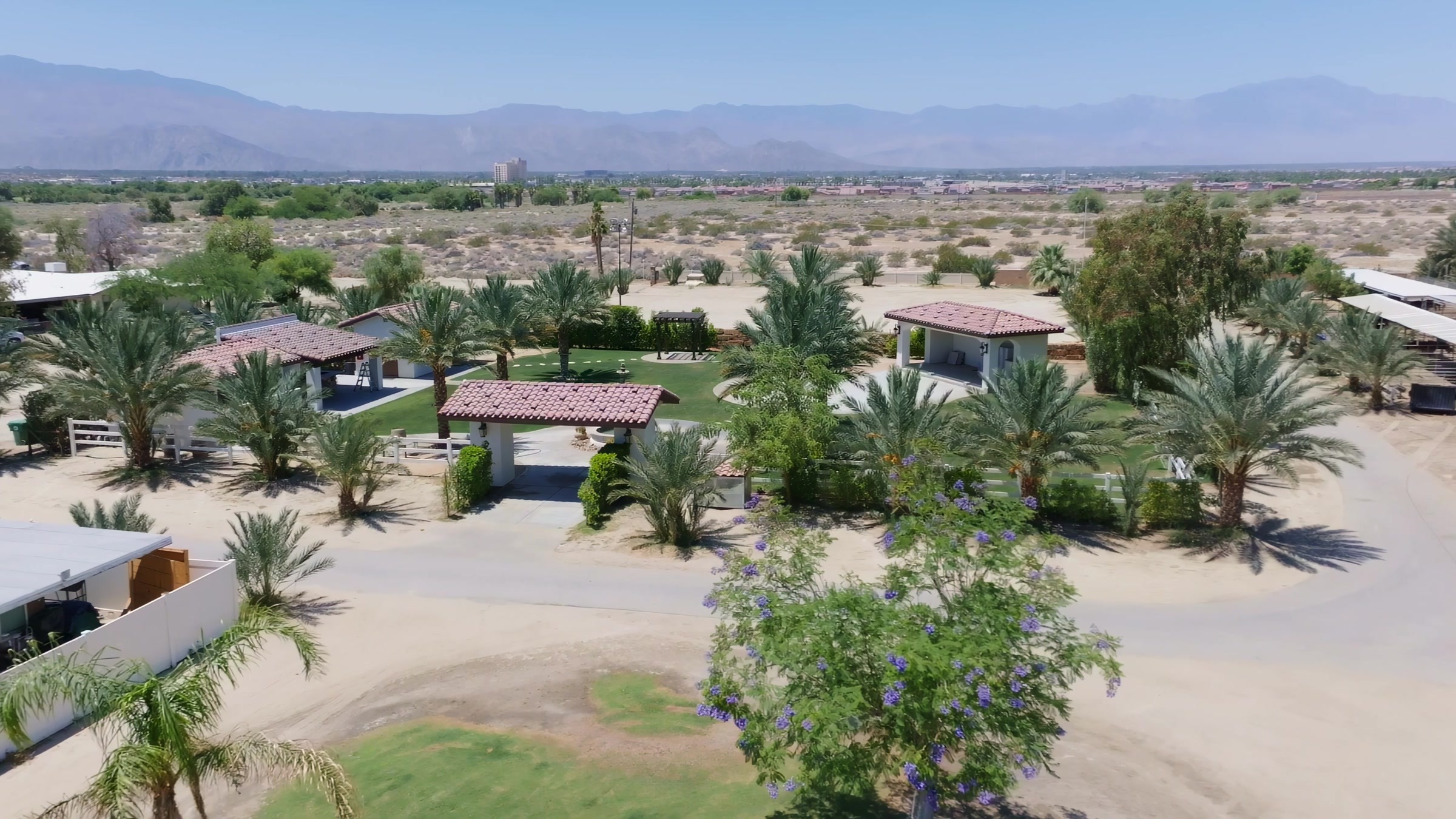 Aerial view of Rancho Escondido property with palm trees and San Jacinto mountain backdrop in Indio.