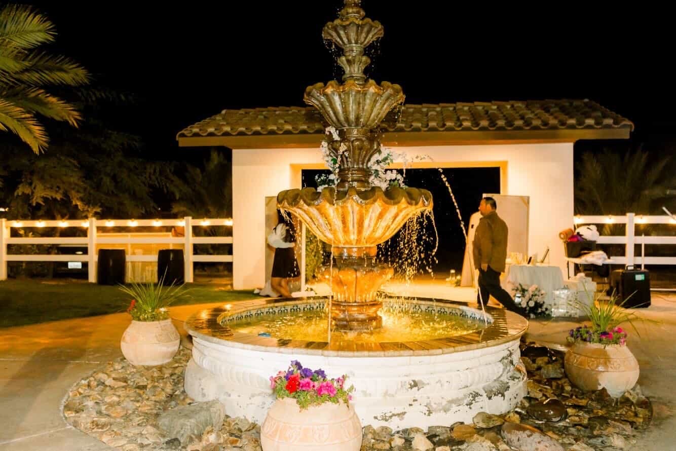 Illuminated fountain courtyard at a Rancho Escondido wedding reception in Indio at night.